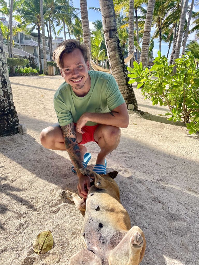 Me petting a stray dog on a beach